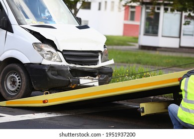 Wrecked white car pulling into tow truck - Shutterstock ID 1951937200