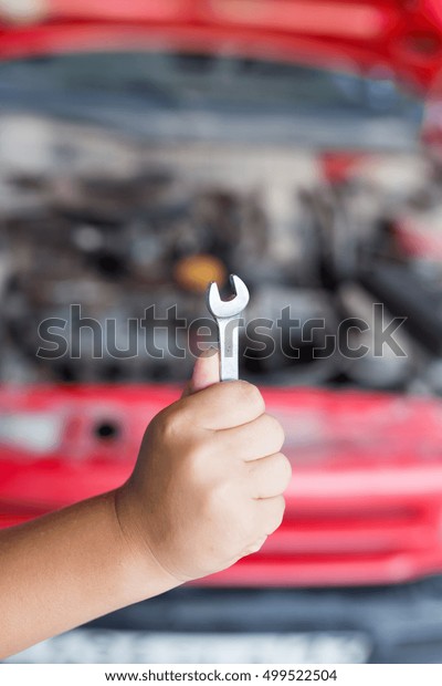 Wrench in hand on the
background of cars