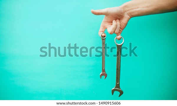 wrench in hands, on a blue\
background