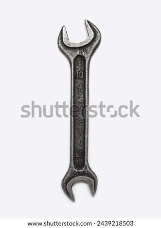 Wrench isolated on a vertical white background. One hand tool top view in the center, no people. Old and dirty metal wrench.