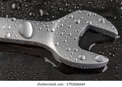 A Wrench For Loosening The Screws. Wet Tools In A Car Repair Shop. Dark Background.