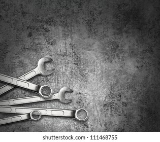 Wrench spanner tools on grunge silver metal background
