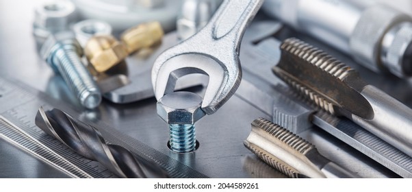 Wrench tightens bolt in steel billet. Spanner, bolt, screw and nuts. - Shutterstock ID 2044589261