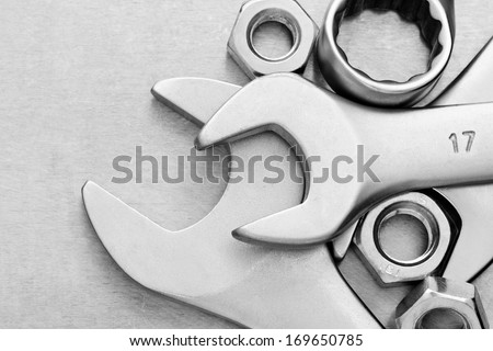 wrench tool and nut at metal  background