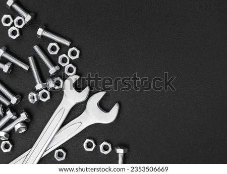 Wrenches with bolts and nuts on black background. Top view. Copyspace..