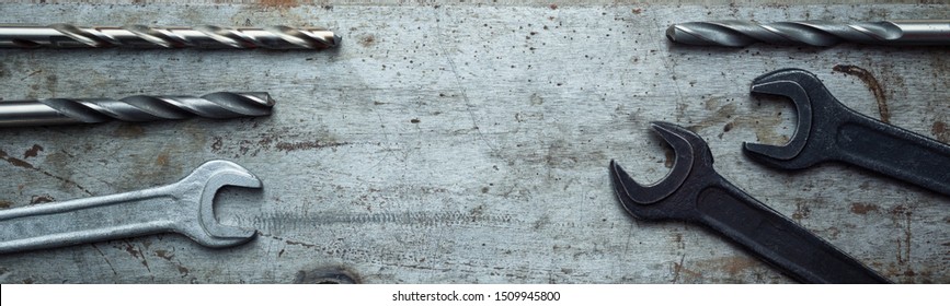 Wrenches And Drills Laid Out On A Textured Steel Bench Metal Sheet. Top View With Copy Space. Flat Lay