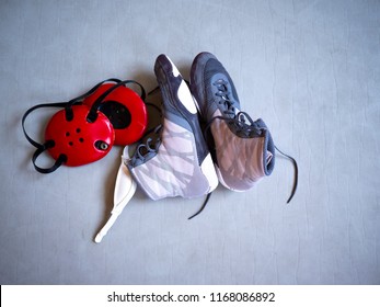 Wrestling Shoes And Headgear On A Grey Mat