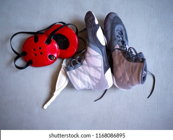 Wrestling Shoes And Headgear On A Grey Mat