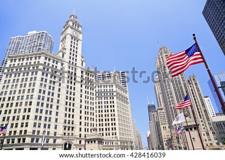 Wrigley Building and Tribune Tower on Michigan Avenue with American flag on the foreground in Chicago, USA