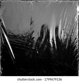 Wrinkle transparent shiny plastic wrap overlay on black background
