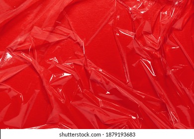 Wrinkled Cling Film, Red Vinyl Background. Abstract, Art Design, Wet Effect Texture. Minimal, Flat Lay.