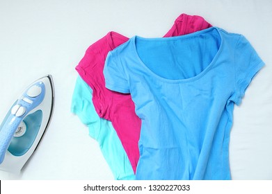 Wrinkled Clothes And Iron On A White Background. View From Above.