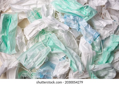 Wrinkled And Dirty Blue, Green And White Disposable Face Mask, Group Of Many Used Mask. Infectious Waste.