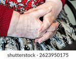 Wrinkled folded hands of an 86 yo grandmother sitting in a wheelchair home in Tienen, Flemish Brabant, Belgium, FEB 16, 2025. Model released