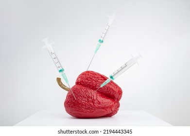 Wrinkled, Withered Red Pepper With Syringes. Concepts Of Healthcare Or Cosmetology, Anti Aging Skin Care Or Beauty Injections. Shallow Depth Of Field