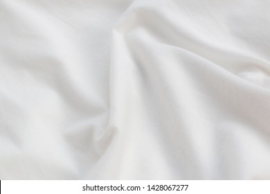 Wrinkles on white cotton fabric, texture, background .