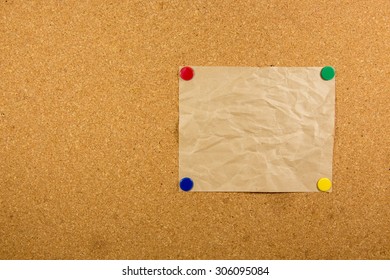 wrinkles paper on cork board with 4 sticky note pinned
