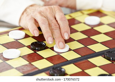 Wrinkly Hand Of A Senior Woman Playing Checkers