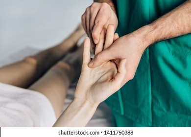 Wrist Massage. A Male Massage Therapist Puts Pressure On A Sensitive Point On A Woman's Hand, 	Massage Of The Joints Of The Ring Finger.