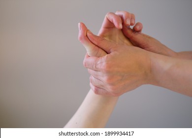 Wrist Massage. Massage Therapist Puts Pressure On A Sensitive Point On A Woman's Hand. Physiotherapist Massaging Her Patients Hand In Medical Office