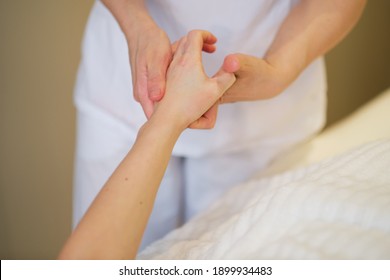 Wrist Massage. Massage Therapist Puts Pressure On A Sensitive Point On A Woman's Hand. Physiotherapist Massaging Her Patients Hand In Medical Office