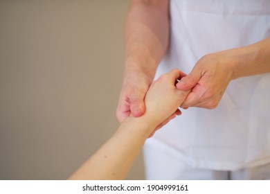 Wrist Massage. Massage Therapist Puts Pressure On A Sensitive Point On A Woman's Hand. Physiotherapist Massaging Her Patients Hand In Medical Office