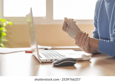 Wrist Support Brace Worn During Remote Work On Laptop To Ease Pain And Prevent Injury - Powered by Shutterstock