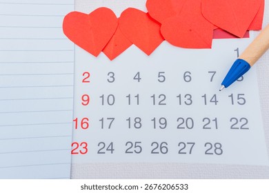Write notes in a notebook with a pen for a business plan, love what you do with a calendar, while making a list of daily finances for Valentine's Day.