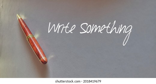 Write Something Wording and A Classic Ball Pen Isolated With Grey Background. Selective Focus 