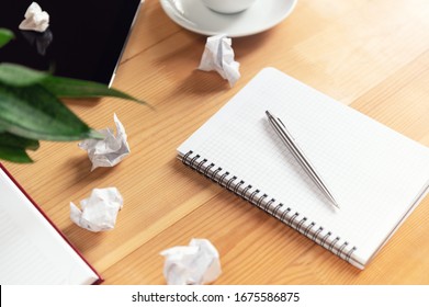 Writer workplace with notepad and pen. Crumpled papers, clear sheet in notebook on wooden table. Business planning and brainstorming. Creation process and authorship concept