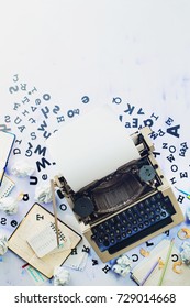 Writer Workplace With Scattered Letters, Stationery And A Typewriter. Crumpled Paper Balls With Pencils On A White Wooden Background, Creative Writing Concept. Flat Lay With Copy Space.