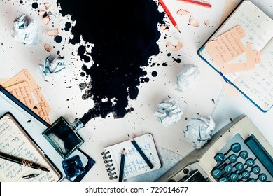 Writer Workplace With Spilled Ink, Stationery And A Typewriter. Crumpled Paper Balls With Pencils On A White Wooden Background, Creative Writing Concept. Flat Lay With Copy Space.