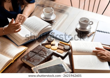 Writers enjoying tea and biscuits while discussing literature at a book club meeting, sharing ideas and insights