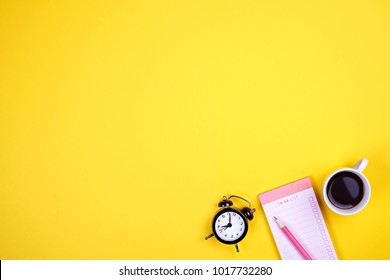 Writer's Table Flat Lay Composition. Student Desk W/ Supplies, Blank Notebook Pages, Coffee Cup, Clipboard, Pencil, Planner, To Do List, Empty Checkbox, Mini Alarm Clock. Copy Space, Yellow Background