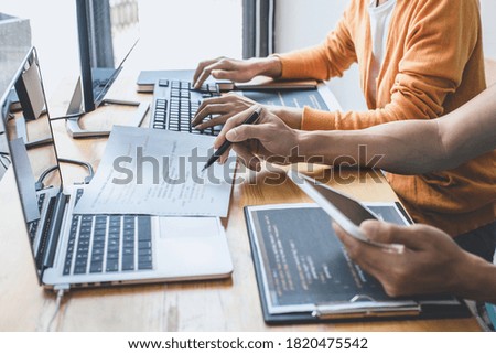 Writing codes and typing data code technology, Programmer cooperating working on web site project in a software developing on desktop computer at company, Programming with HTML, PHP and javascript.