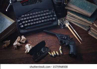 Writing A Crime Fiction Book - Old Retro Vintage Typewriter And Revolver Gun With Ammunitions, Books, Papers, Old Ink Pen On Wooden Table