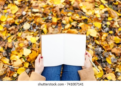 Writing hand, blank space note in autumn park. To do list, goals, inspiration concept. Creative date