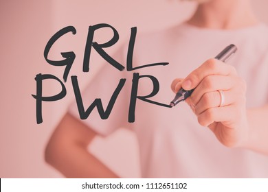 Writing hand. Woman holds pen or marker and writing GRL PWR. Abbreviation for the feminist slogan Girl Power - Powered by Shutterstock