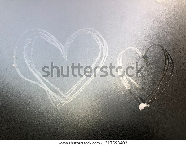 Writing heart on the surface of the\
milk glass background texture of car\'s window in grey\
color