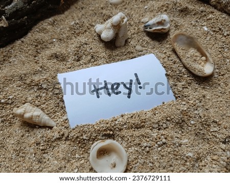 The writing hey on the beach sand background.