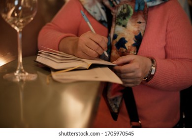 Writing notations in a notebook. Pen in the hand. Notepad can serve in different ways: for preserving memories and happy moments, for achieving goals and taming time, as a language simulator and more.