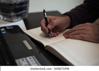Writing in notebook.