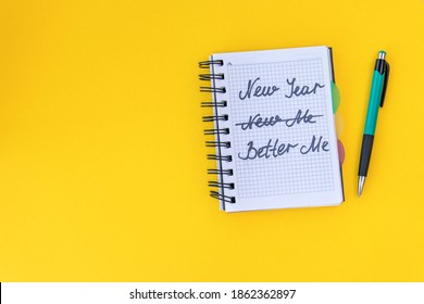 Writing In A Notebook New Year, Better Me On Yellow Background Happy New Year Quote. Top View. Flat Lay