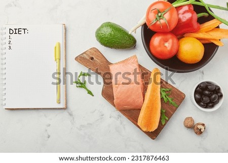 Writing a notepad with text diet, copy space. Fodmap, Mediterranean, Paleo, diet concept. Healthy low fodmap ingredients - vegetables, fruits, salmon, nuts, greens.