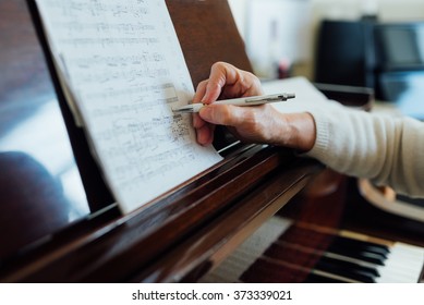 writing notes on sheet music close-up