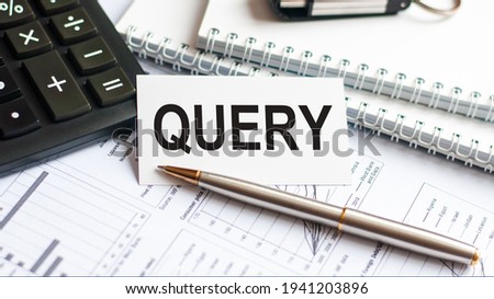 Writing text QUERY on white paper card, black letters, pen and diagram on white background. Business concept.