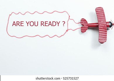 writing are you ready red toy airplane with talk bubble on white background