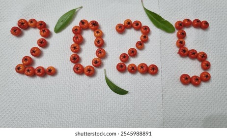 Written new year 2025  red orange berries green leafs top view decoration. Mobile shot  - Powered by Shutterstock