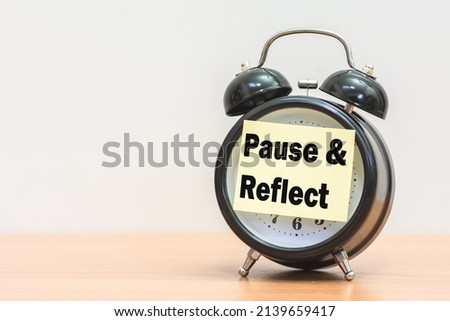 Written pause  reflect with paper on alarm clock.
Pause and reflect word with time concept. Сток-фото © 