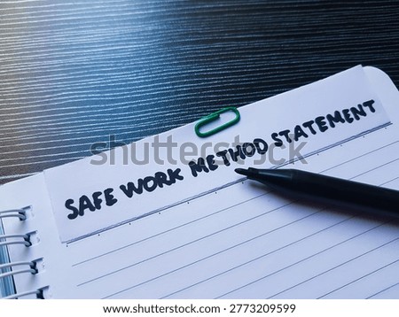 The writting safe work method  statement on table background. 